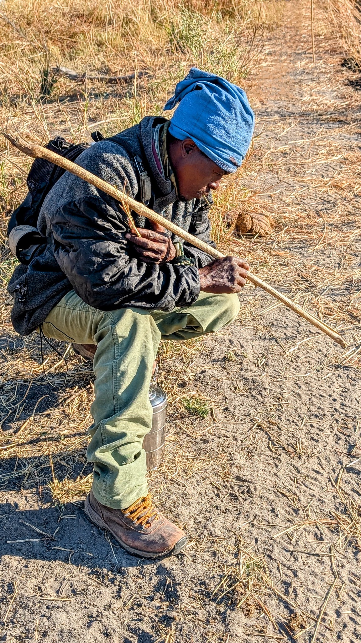 A local Okavango Delta poler preparing his wooden pole before guiding a mokoro experience