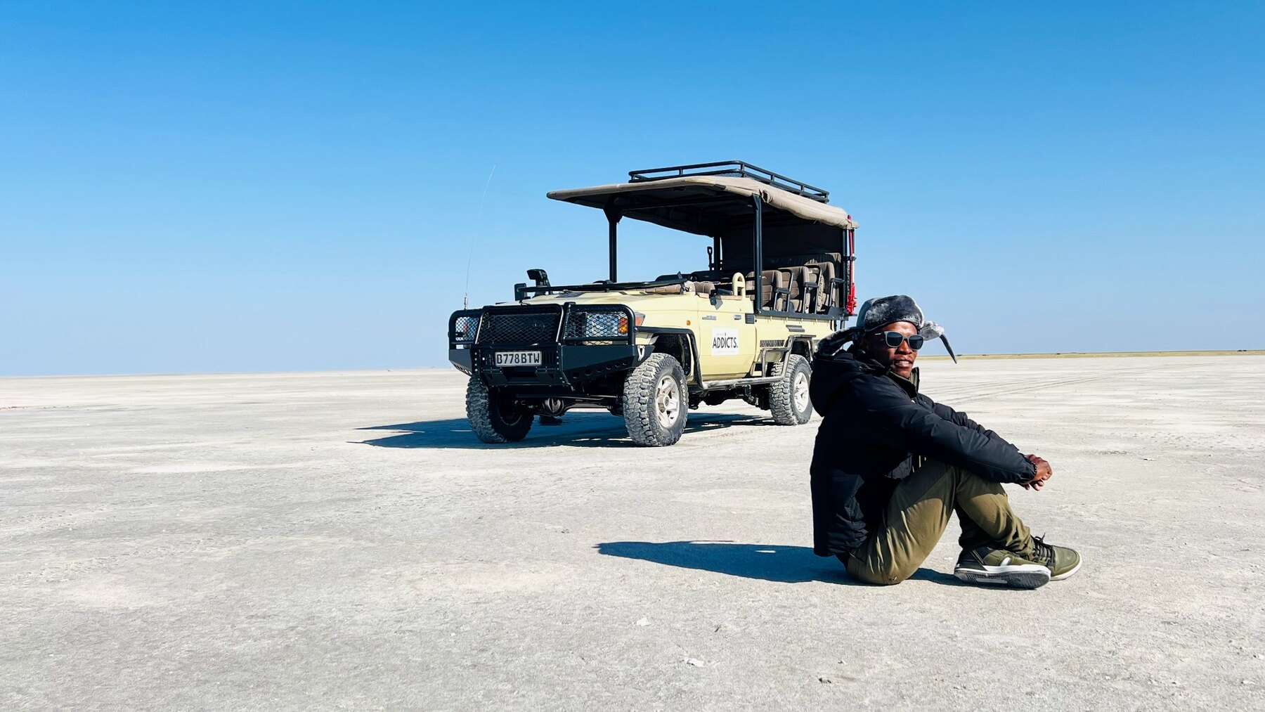 Thato Pressie beside a Safari Addicts vehicle on Botswana's salt pans